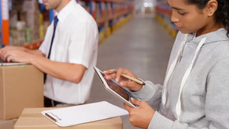 Workers-checking-boxes-with-clipboard-and-tablet-computer