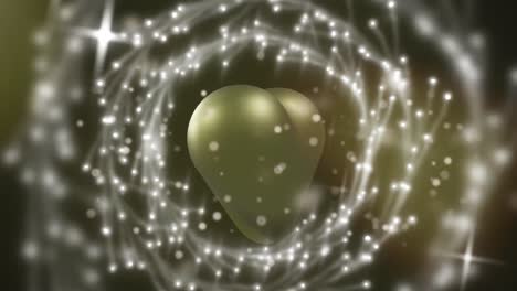 animation of light spots and circles over gold heart on black background