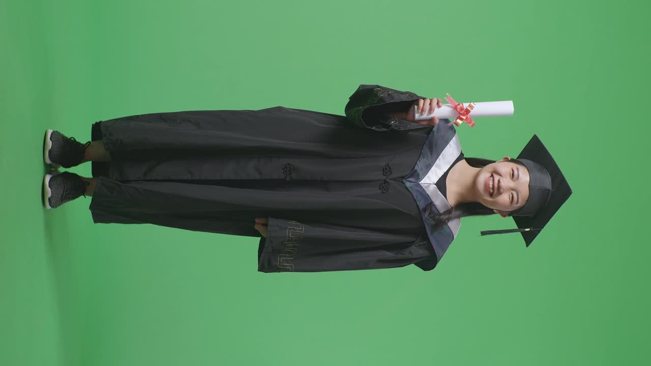 Donna in toga di laurea che tiene un diploma