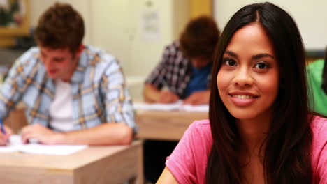 student smiling to camera in classroom