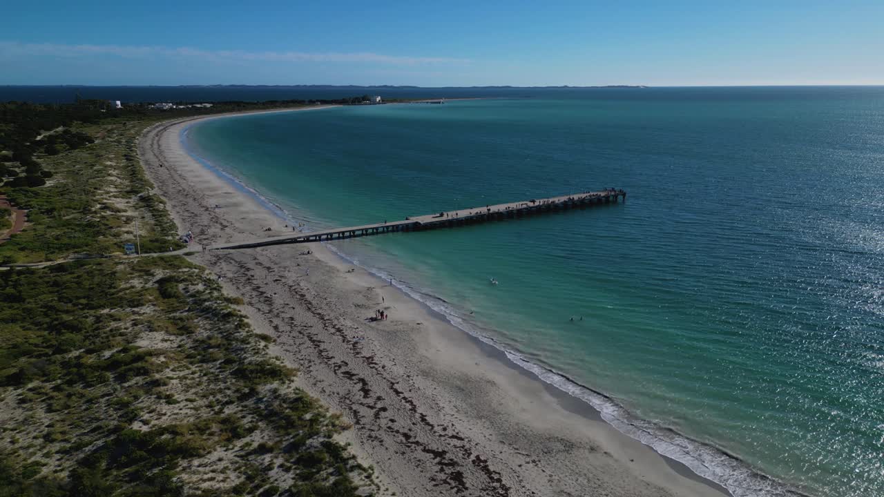 drone aéreo en movimiento hacia adelante disparado sobre turistas bañándose a lo largo de la playa de coogee, perth, australia occidental en un brillante día soleado