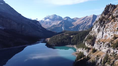 drone flight above the famous deep-blue lake called oeschinensee, inbetween the swiss alps