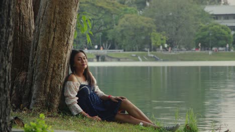 una mujer relajándose junto al lago.
