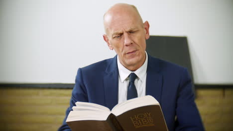 un hombre de negocios profesional está leyendo la santa biblia en casa