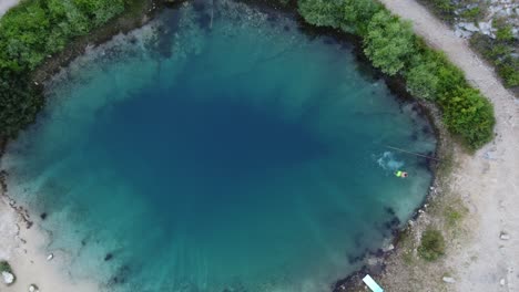 Gente-Nadando,-Saltando-Al-Agua-Fría-Del-Manantial-Del-Río-Cetina,-También-Conocido-Como-El-Ojo-De-La-Tierra,-Un-Manantial-Kárstico-Y-Un-Agujero-Azul-Profundo,-Croacia