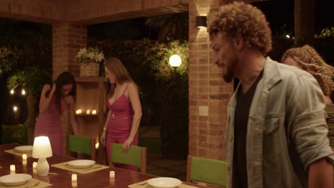 friends enjoying a lively dinner party on an outdoor patio at night