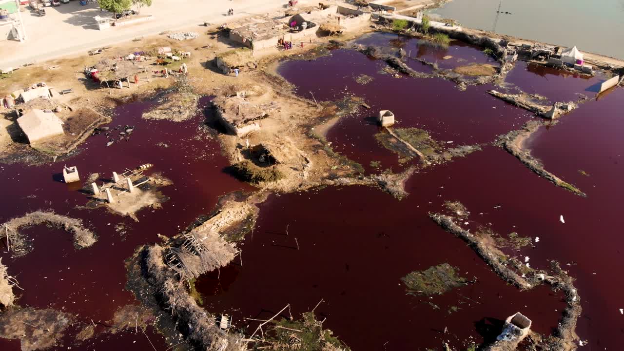 vista aérea de aguas podridas y rancias de color rojo oscuro en daharki