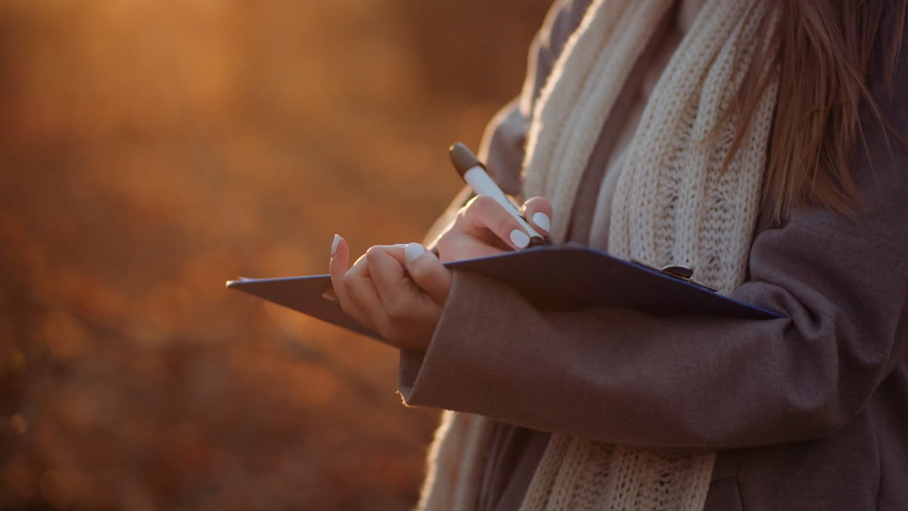 Woman Writing On Clipboard Against Sun