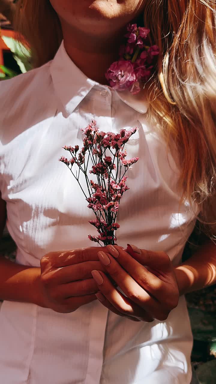 Donna con un bouquet di fiori rosa
