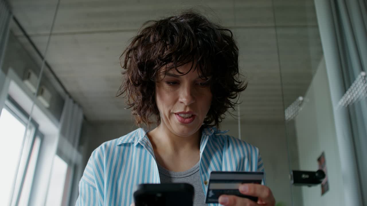 mujer usando un teléfono inteligente para hacer un pago en línea con una tarjeta de crédito