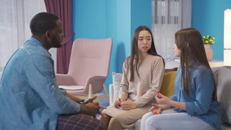 asian, european and african university students chatting at home.