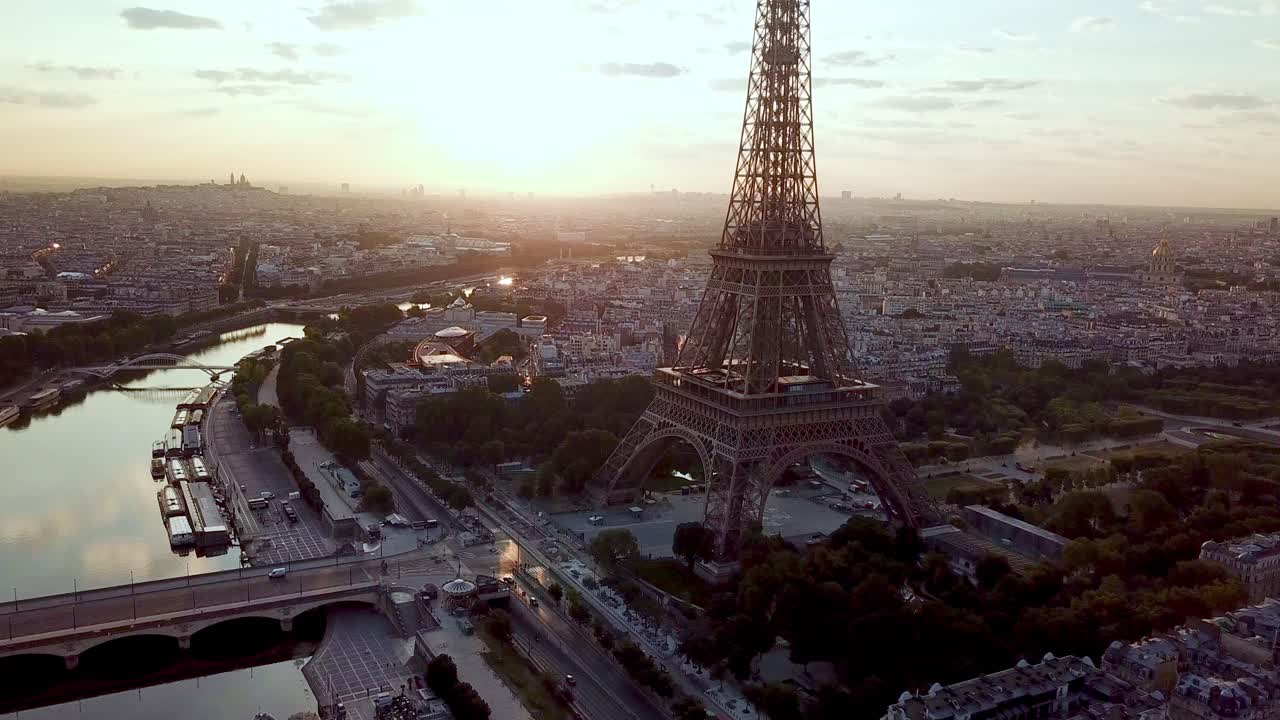 Drone circular around Eiffel tower, above Seine River. Facing Montmartre