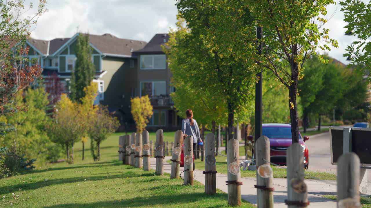 한낮에 캐나다의 안전한 지역사회에서 마차에 아이를 태우고 있는 어머니