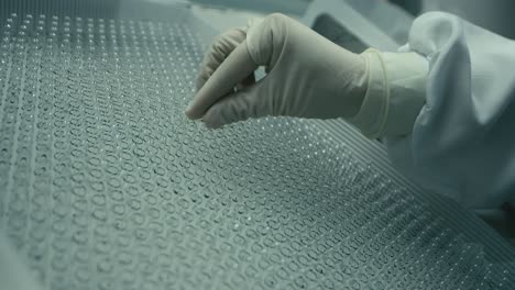 hands of surgeon taking out ampule from a tray full of ampules