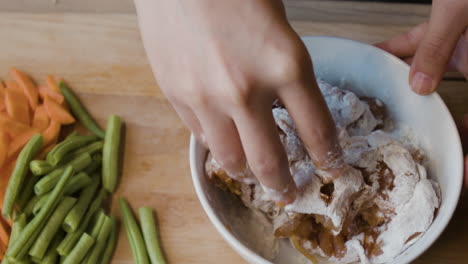 hands mixing ingredients for a meal