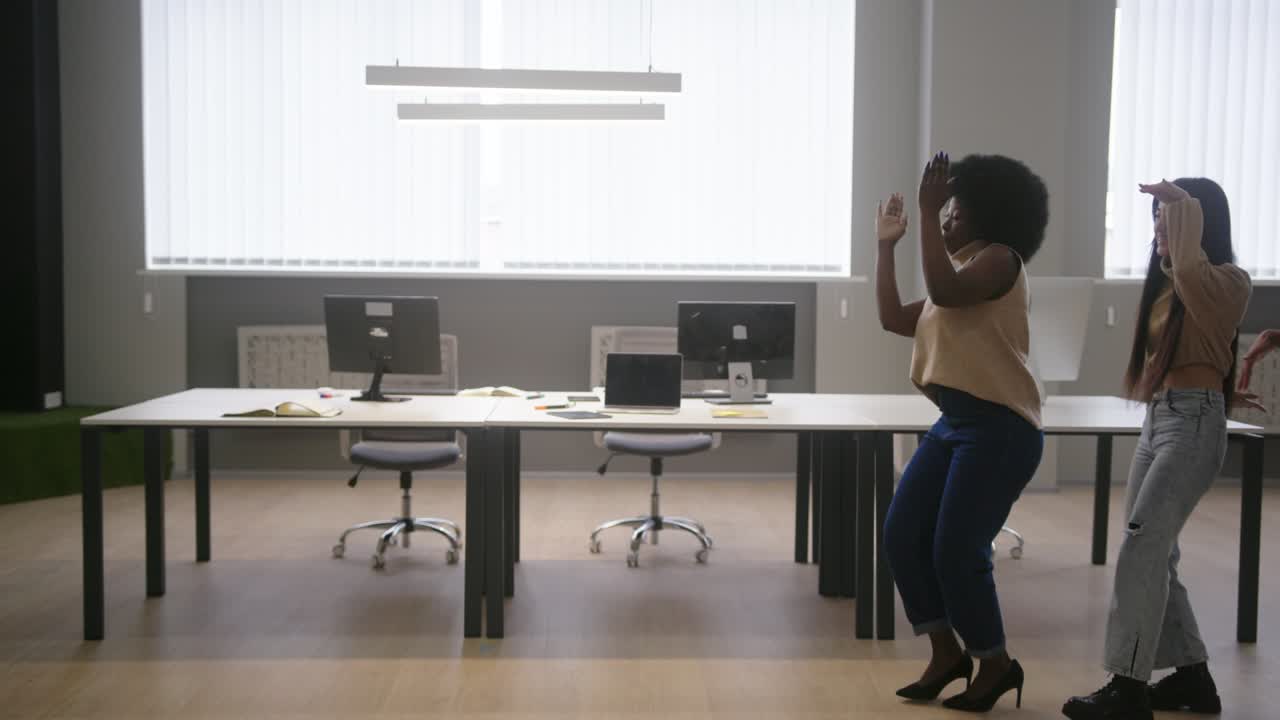 Multinational employees go in single file dancing in office