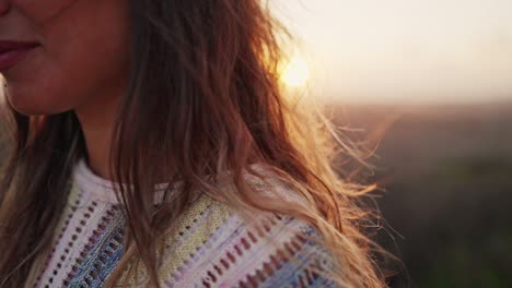 close up of young girl´s brunette hair waving with wind in slow motion at sunset