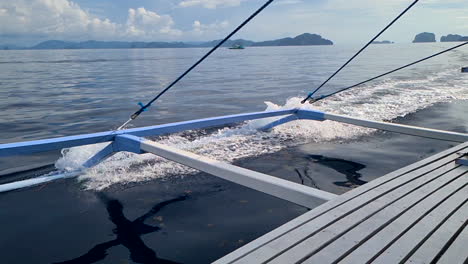 slow motion, balangay traditional filipino catamaran boat sailing between island, passenger pov