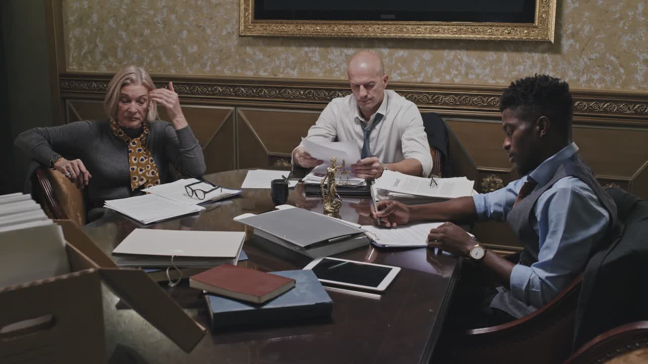 abogados cansados trabajando con papeles en la oficina