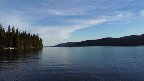 drone flying over wooden jetty by the lake with dense vegetation