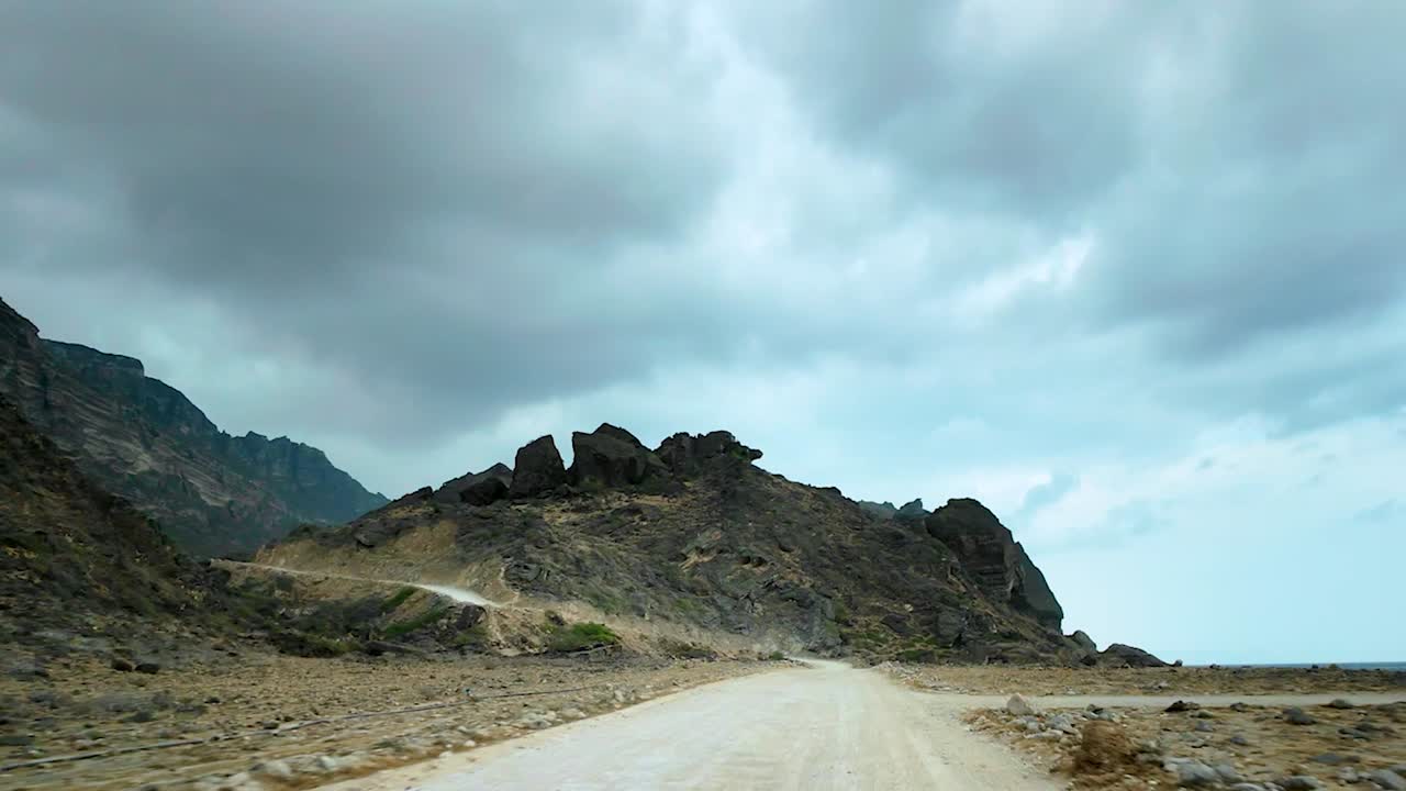 Driving along a remote dirt road in Oman to reveal a hidden beach in slow motion