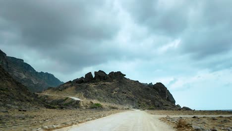 driving along a remote dirt road in oman to reveal a hidden beach in slow motion