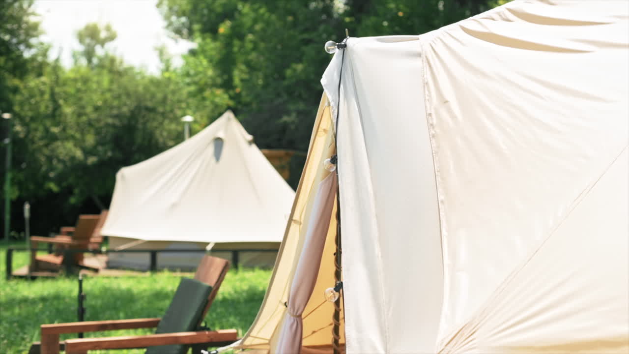 Couple entering the tent. Young man and woman. Greenery around. Glamping. Slow motion