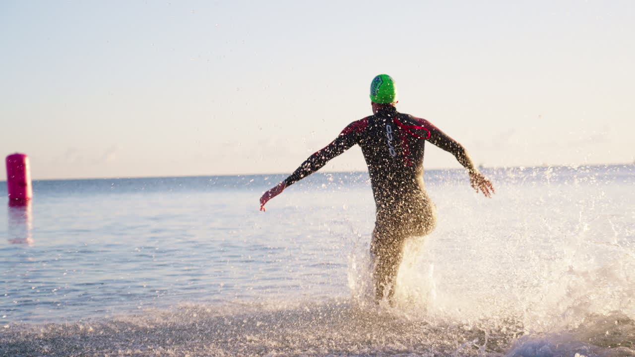 Fit Athlete Running Splashing Into Ocean Water During Competitive Ultra Race, 4K Slow Motion