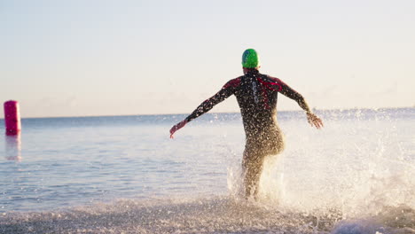 Atleta-En-Forma-Corriendo-Chapoteando-En-El-Agua-Del-Océano-Durante-Una-Carrera-Ultra-Competitiva,-Cámara-Lenta-De-4k