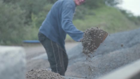 hard working man shovelling sand onto pickup bed