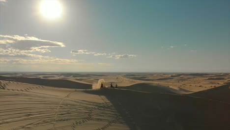 Luftaufnahmen-Von-Wüstensanddünen-Mit-Motocross-Fahrern-Und-Einem-Laufenden-Mann