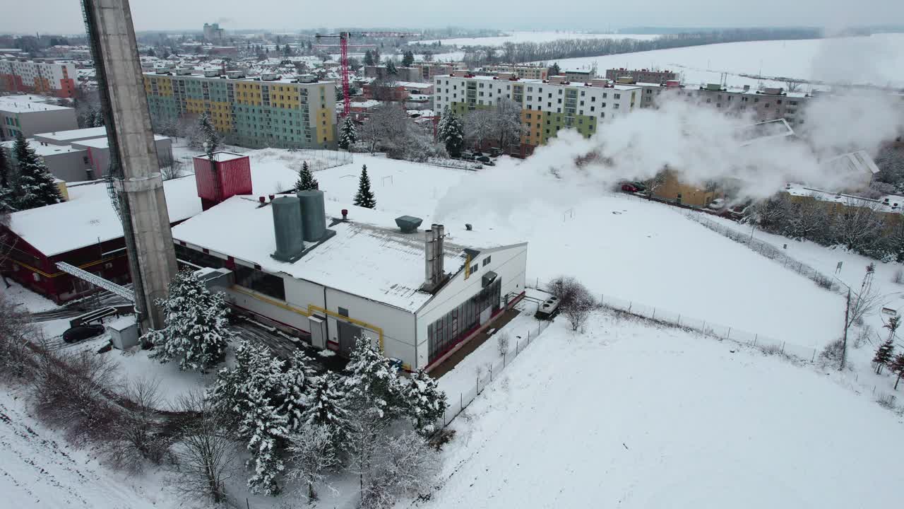 겨울에는 도시 주변에 흰 연기를 내뿜는 굴뚝이 있는 난방 시설, 배경에는 아파트 블록