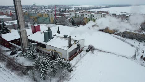 Heizwerk-Mit-Schornsteinen,-Die-Weißen-Rauch-Durch-Die-Stadt-Dampfen,-Im-Winter-Wohnblöcke-Im-Hintergrund