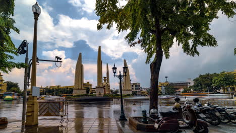 The-sun-comes-out-again-after-rain-at-Democracy-Monument,-Bangkok