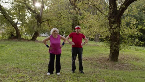 Senior-active-couple-doing-sport-physical-exercises-outdoor-in-city-park.-Morning-stretching-workout