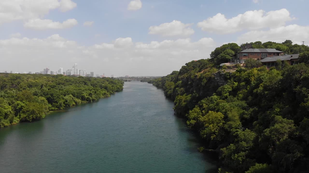오스틴 텍사스에 있는 마을 호수의 상승 샷, 백그라운드에서 도시 시내 스카이라인을 드러내기 위해 천천히 팬을 쐈습니다.