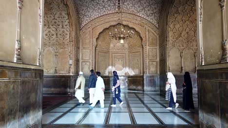 shot of muslim people walking inside the badshahi mosque in lahore pakistan