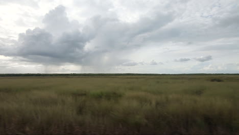 POV-Vom-Fahrenden-Fahrzeug-Entlang-Von-Feuchtgebieten-Mit-Regen-Im-Hintergrund-Kakadu-Nationalpark