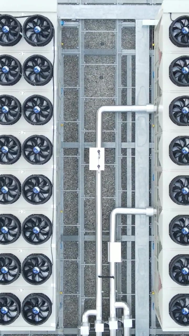 Top-down aerial view of ventilators on a data storage center roof. Vertical video