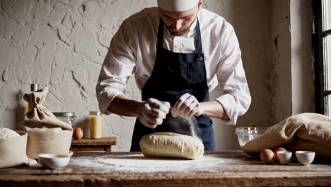 baker sprinkling flour on dough