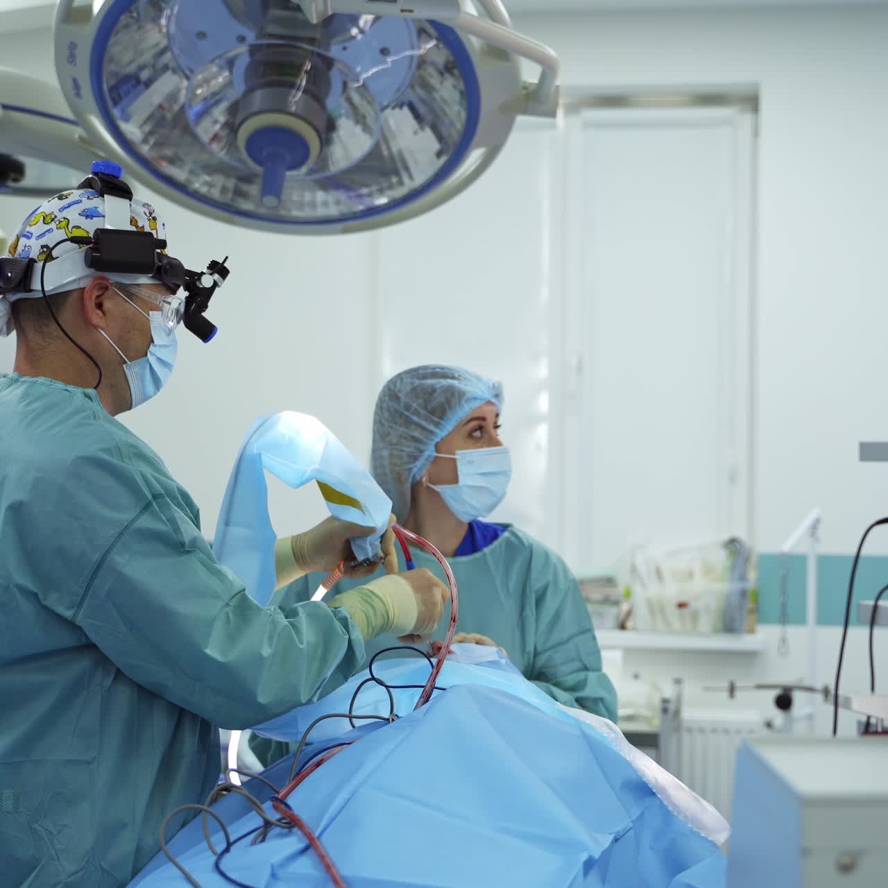 Surgery professional inputs instrument with micro camera into patient's nose. Surgeon looks at the big screen in front of him