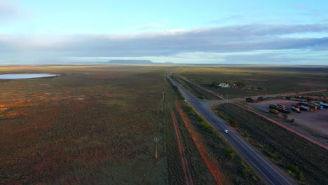 Stuart-Highway-Zwischen-Der-Weiten-Landschaft-Mit-Fernblick-Auf-Eine-Kleine-Oase-In-Australien