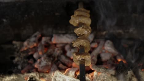 raw chicken in skewer grilled over charcoal with smoke