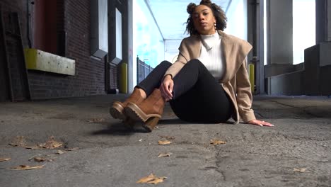 Black-model-poses-for-a-photographer-in-an-alleyway