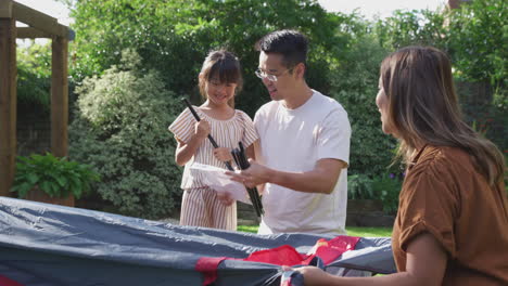Asiatische-Familie-Hat-Spaß-Im-Heimischen-Garten-Und-Baut-Gemeinsam-Ein-Zelt-Für-Einen-Sommercampingausflug-Auf