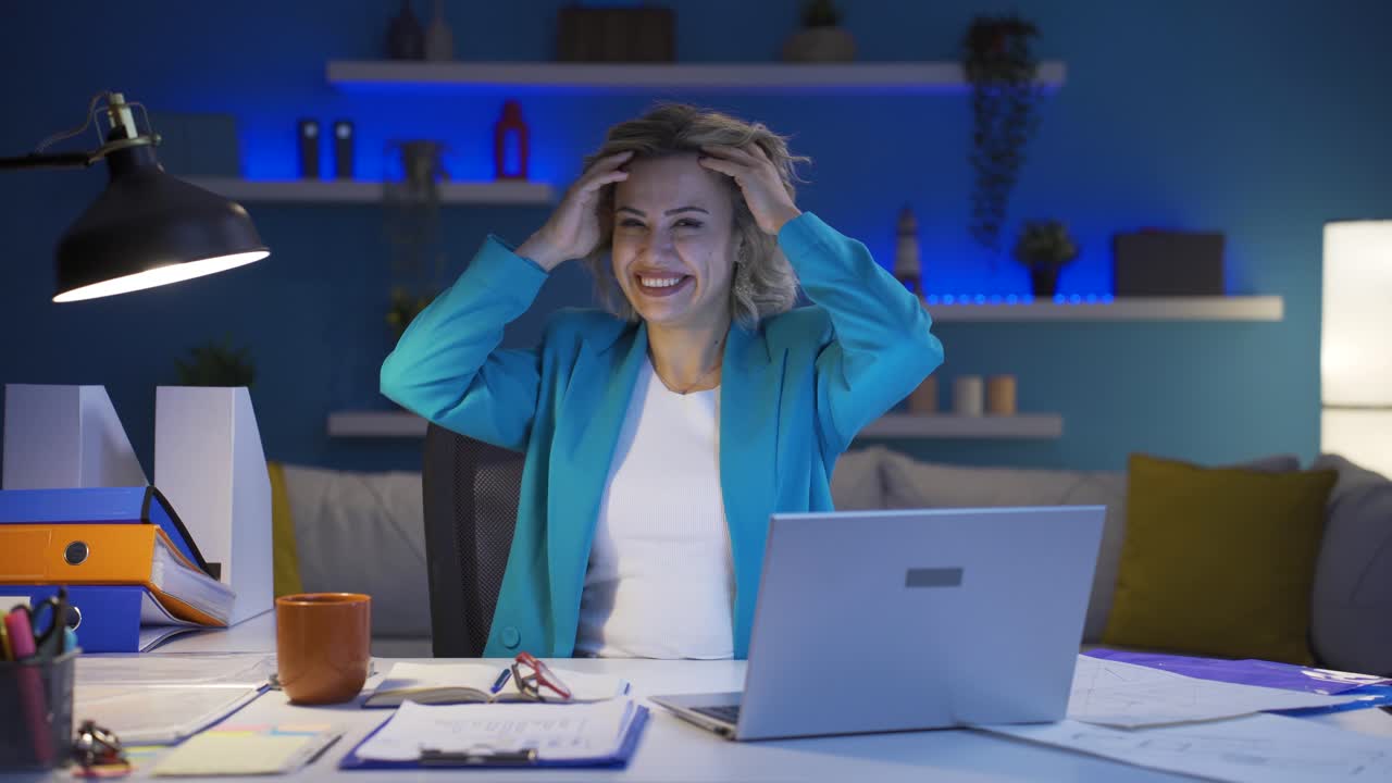 Home office worker woman dances looking at camera.