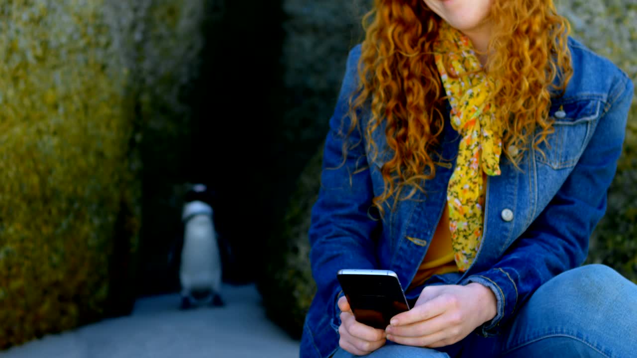 mujer usando teléfono móvil en la playa 4k