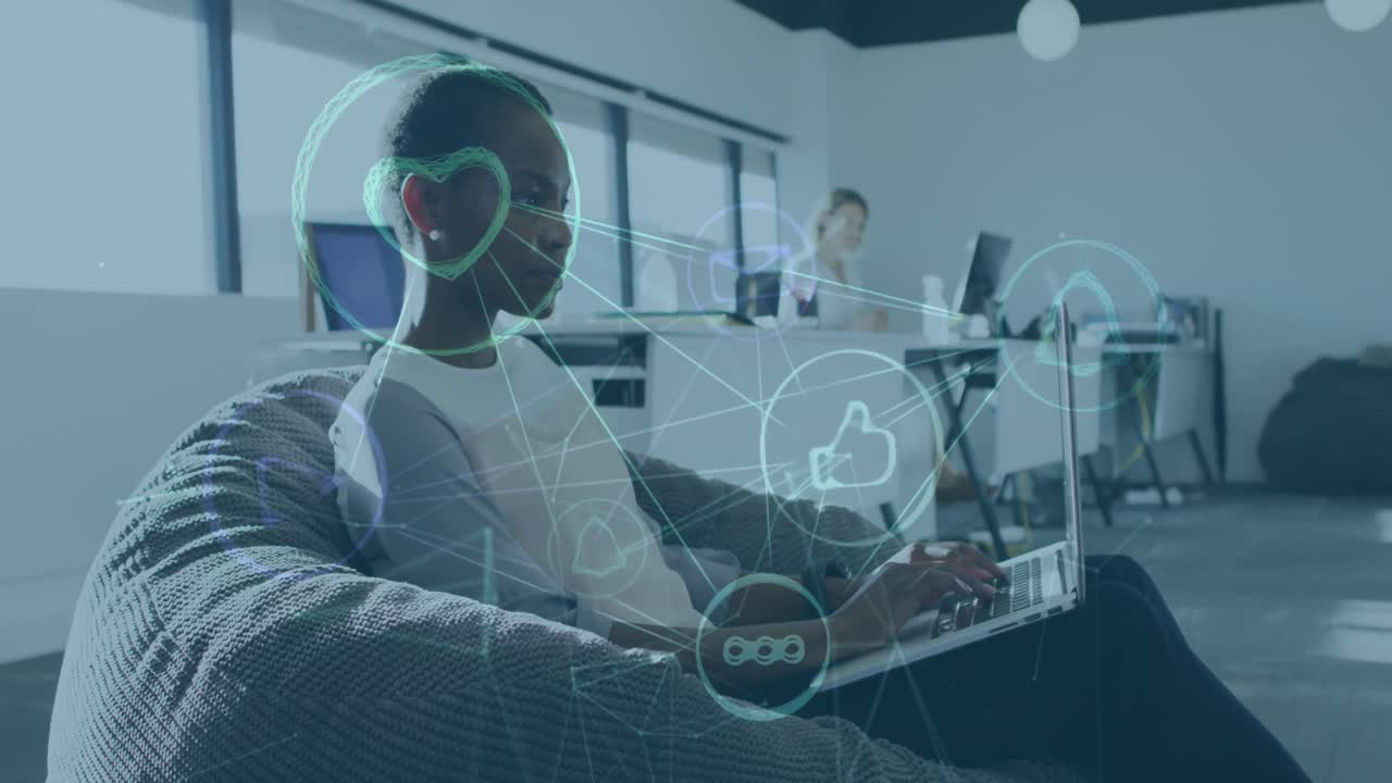 Animation of network of social media icons over african american woman using laptop in office