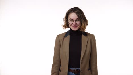 beautiful young brunette woman in glasses with finger on lips showing silent or hush gesture and wink playfully isolated on white background. girl wearing black blazer and strict brown jacket