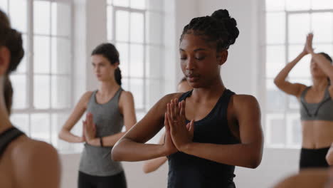 Hermosa-Mujer-Afroamericana-De-Yoga-Practicando-Meditación-En-Pose-Traingle-Con-Un-Grupo-De-Mujeres-Multirraciales-Disfrutando-De-Un-Estilo-De-Vida-Saludable-Haciendo-Ejercicio-En-Un-Gimnasio-Al-Amanecer.